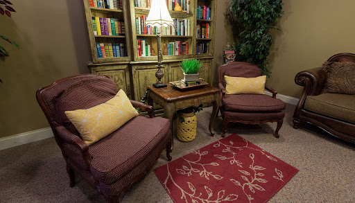 A cozy reading nook featuring comfortable chairs and a well-stocked bookshelf, perfect for relaxing with a book.