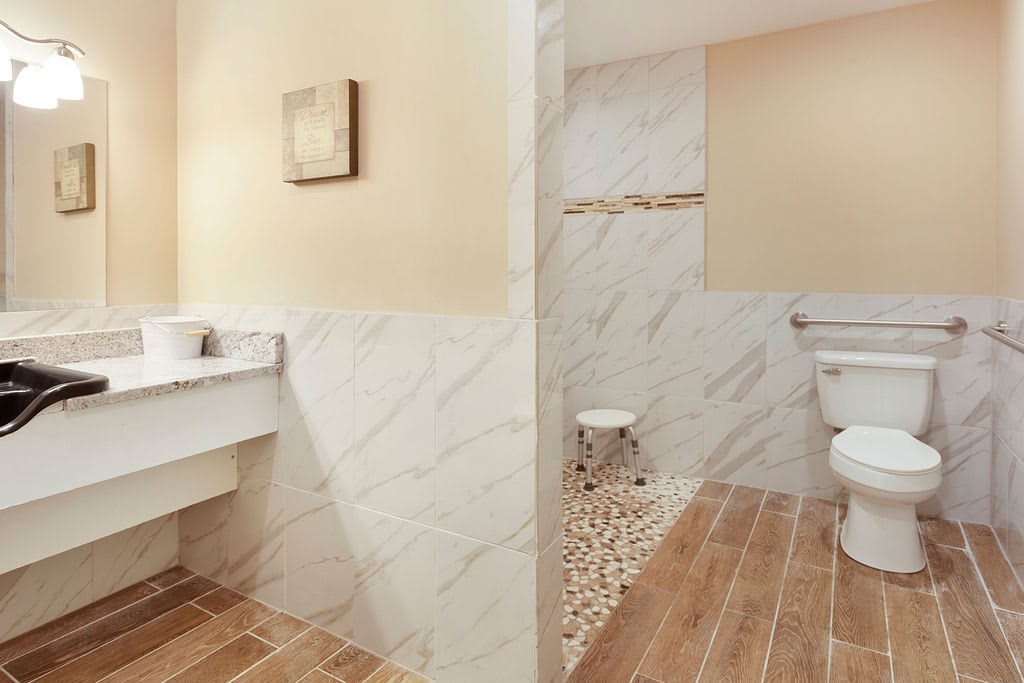 Modern bathroom with ceramic tiles and wooden flooring.