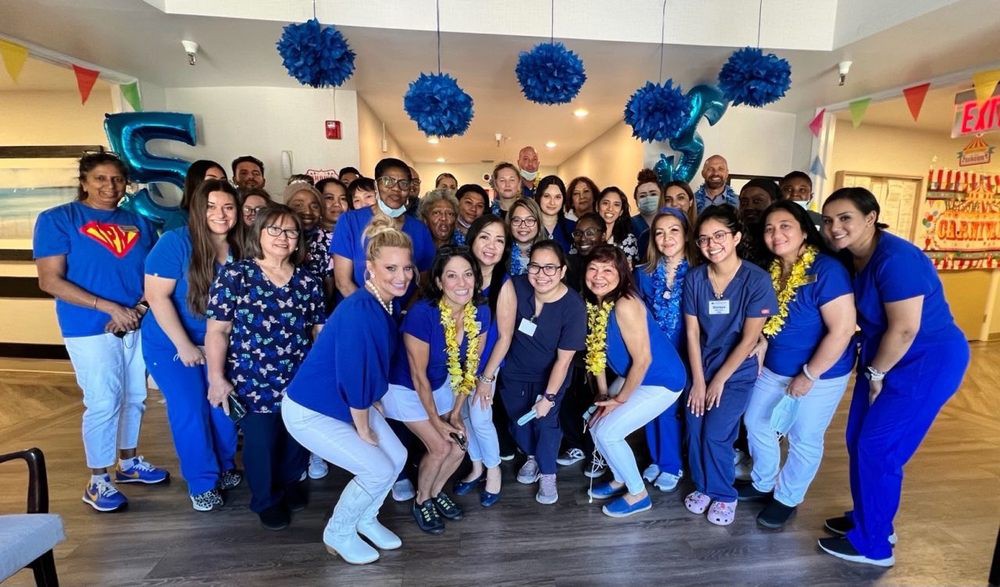 A group of people posing together in a festive, blue-themed setting.