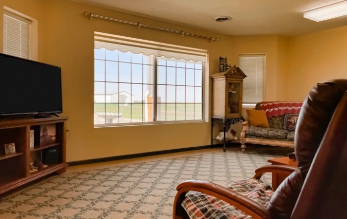 A cozy living room with a large window and comfortable seating.