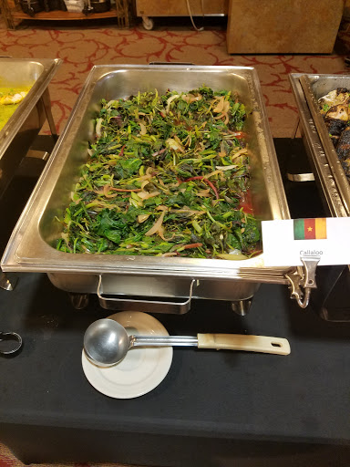 A tray of vibrant, fresh vegetable dish from Cameroon, showcasing a mix of leafy greens.