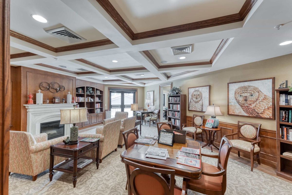 A cozy and well-decorated living room with comfortable seating, bookshelves, and elegant furnishings.