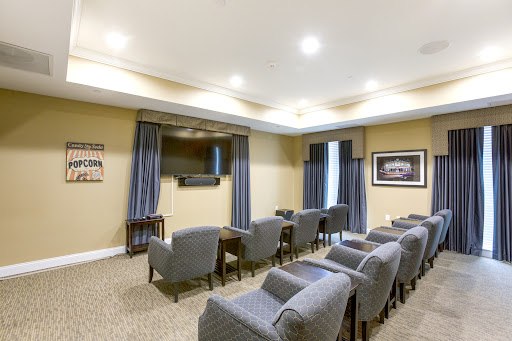 A well-furnished meeting room equipped with comfortable seating and a television, ideal for presentations and discussions.