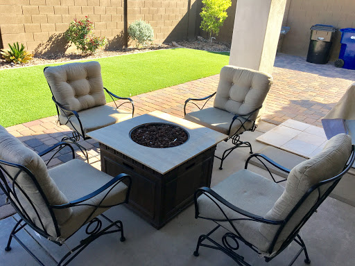 A cozy outdoor seating arrangement featuring a fire pit surrounded by comfortable chairs.