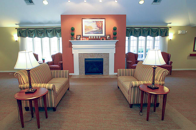 A cozy living room featuring a fireplace, two sofas, and elegant decor.