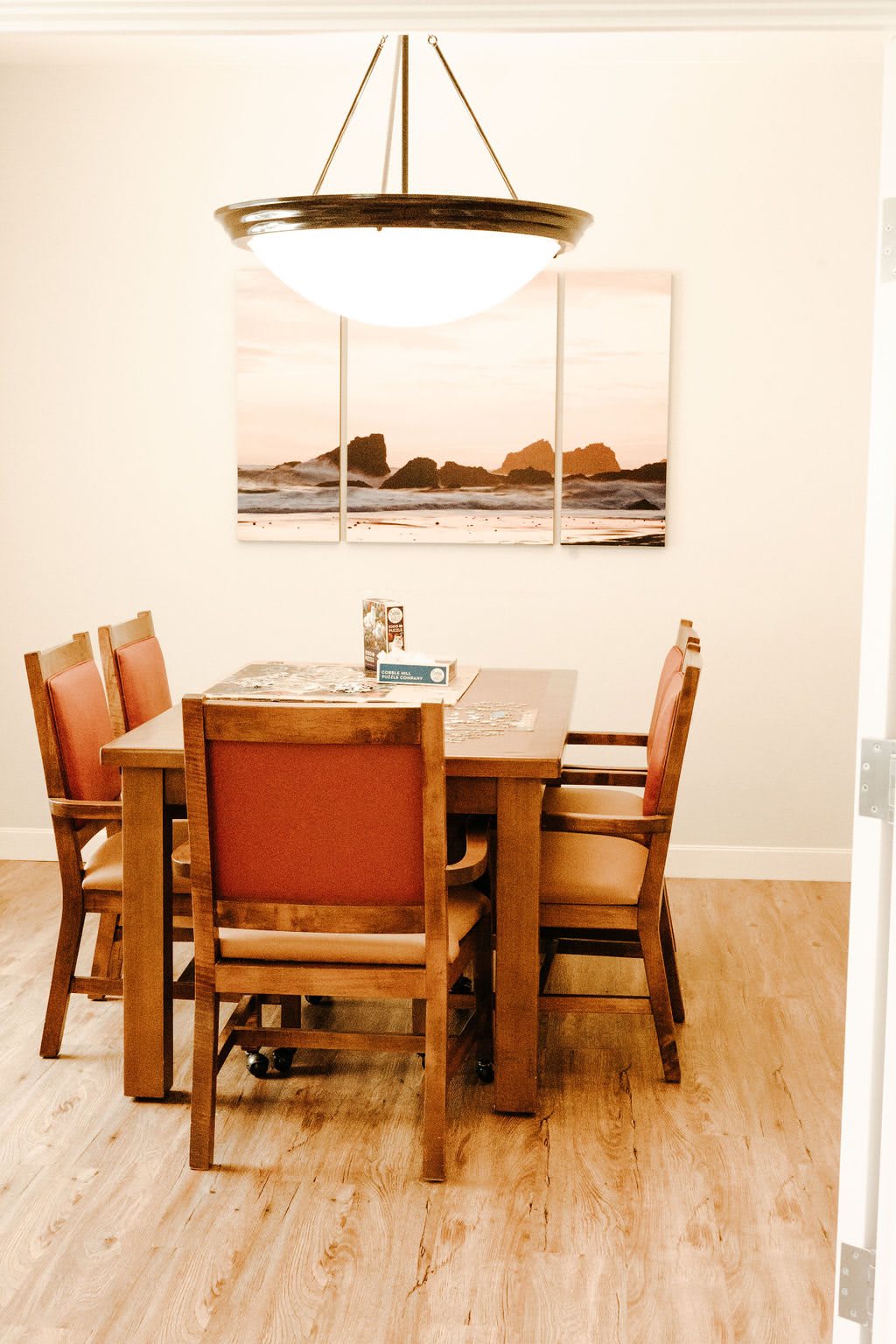 A cozy dining area with wooden furniture and wall art.