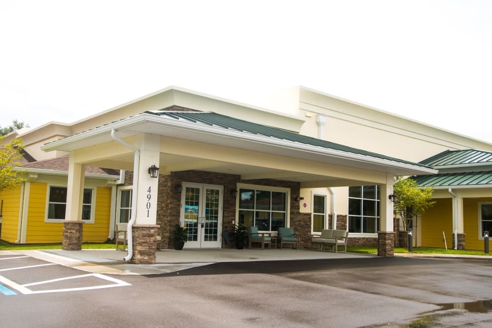 A commercial building with a covered entrance and large windows.