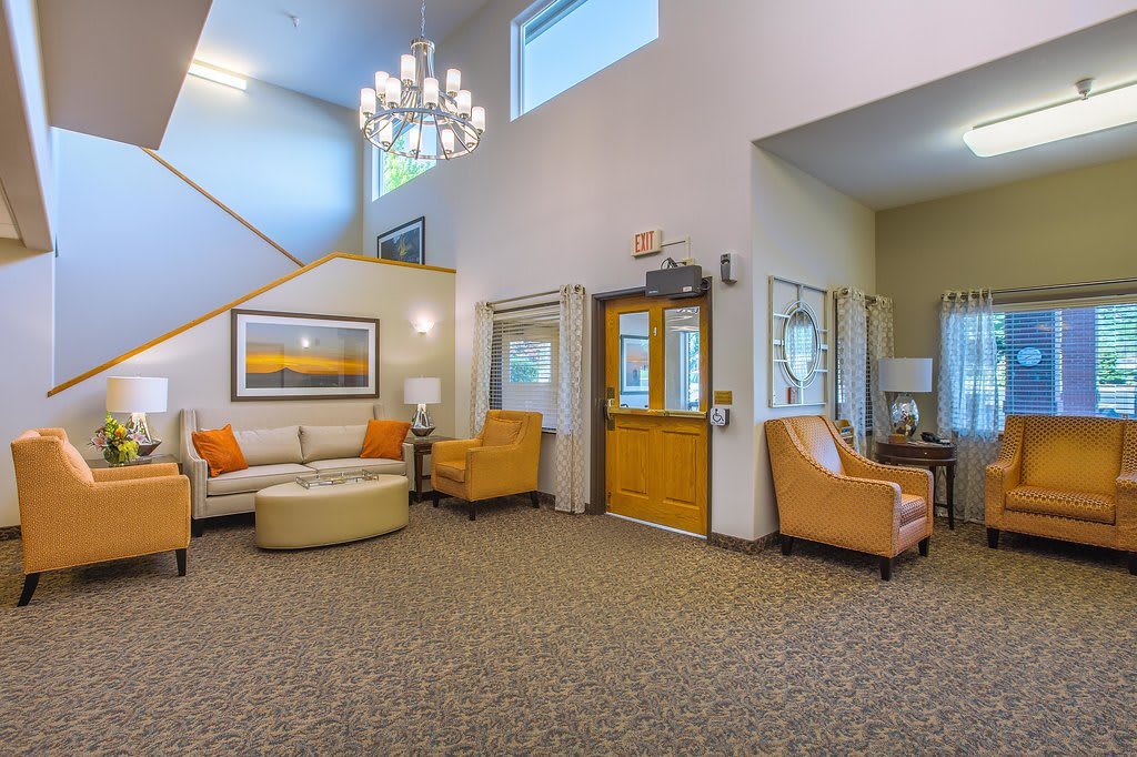 A modern lobby with comfortable seating, featuring a chandelier and contemporary decor.