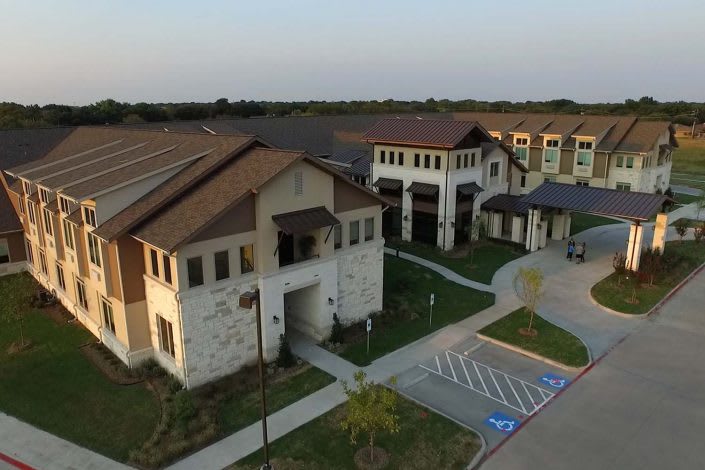 Aerial view of a large building complex with pathways and parking areas.