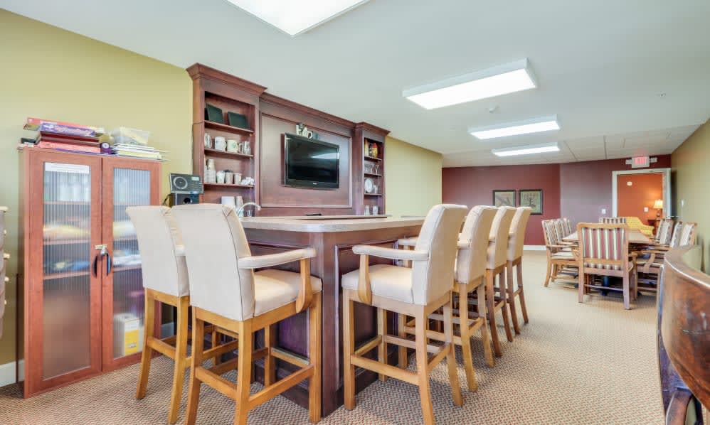 A cozy bar area with high chairs and a television, offering a welcoming space for relaxation.