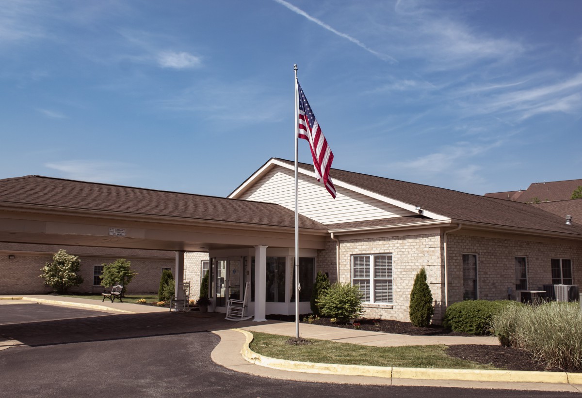 A building with an American flag at the entrance under a clear blue sky.
