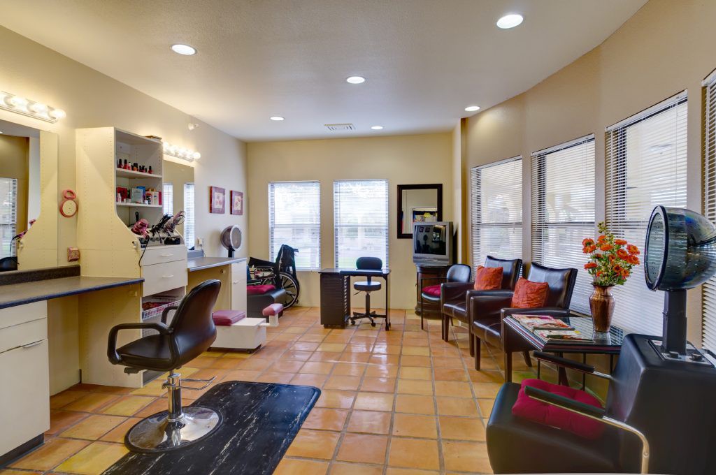 A bright and cozy salon interior featuring a hairdressing station and a comfortable waiting area with plush chairs.