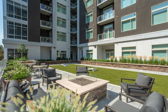 Modern apartment complex with outdoor patio and fire pit.