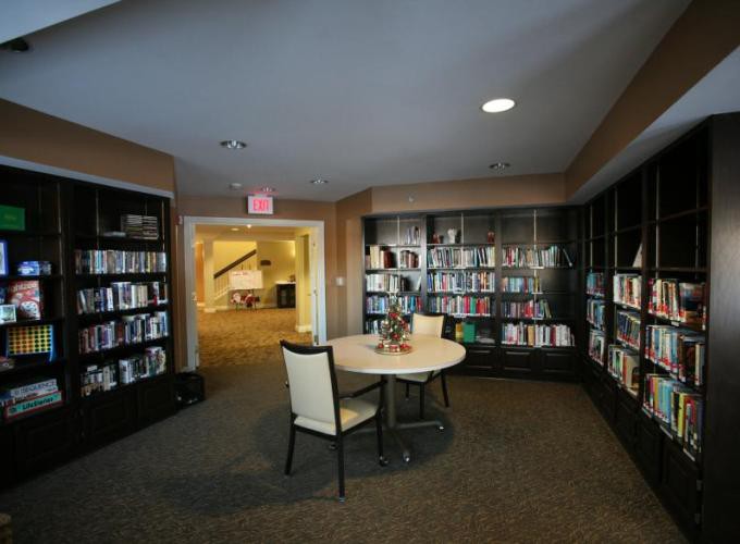 A cozy library corner with bookshelves, a small table, and chairs.