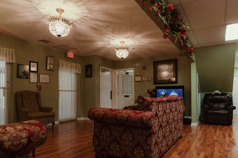 A cozy living room with a patterned sofa, wooden floor, and decorative lighting.