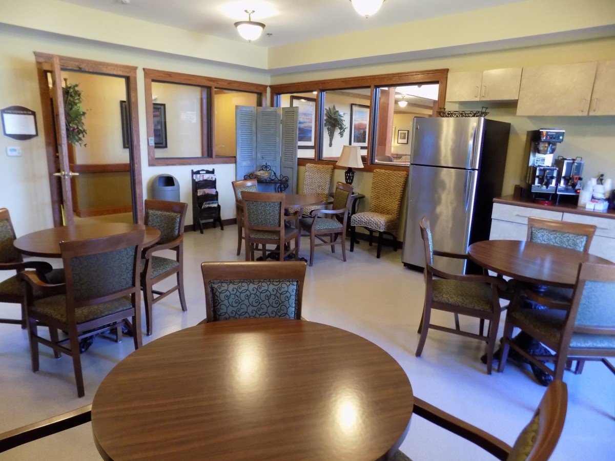 A communal kitchen and dining area with tables, chairs, and modern appliances.