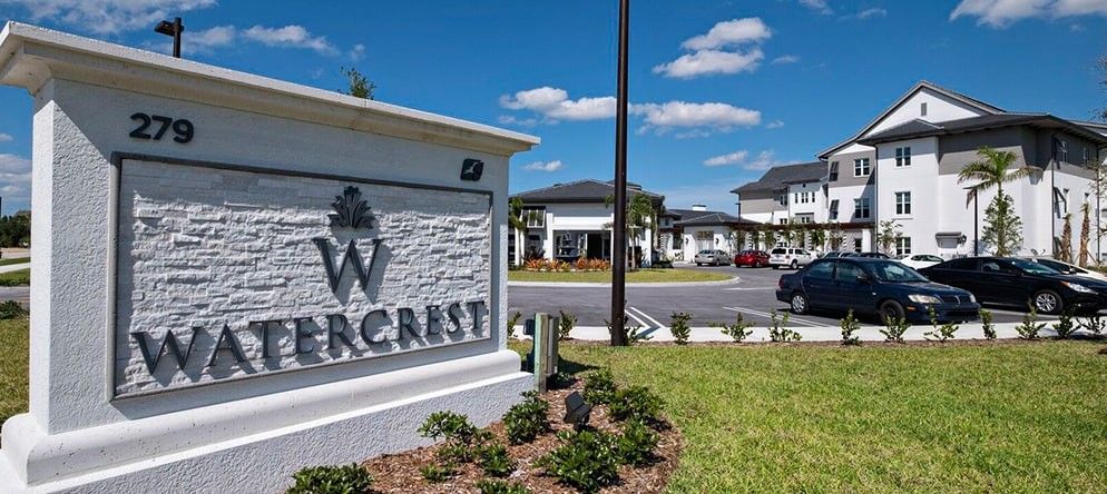 Entrance sign for a residential complex on a sunny day with clear skies.