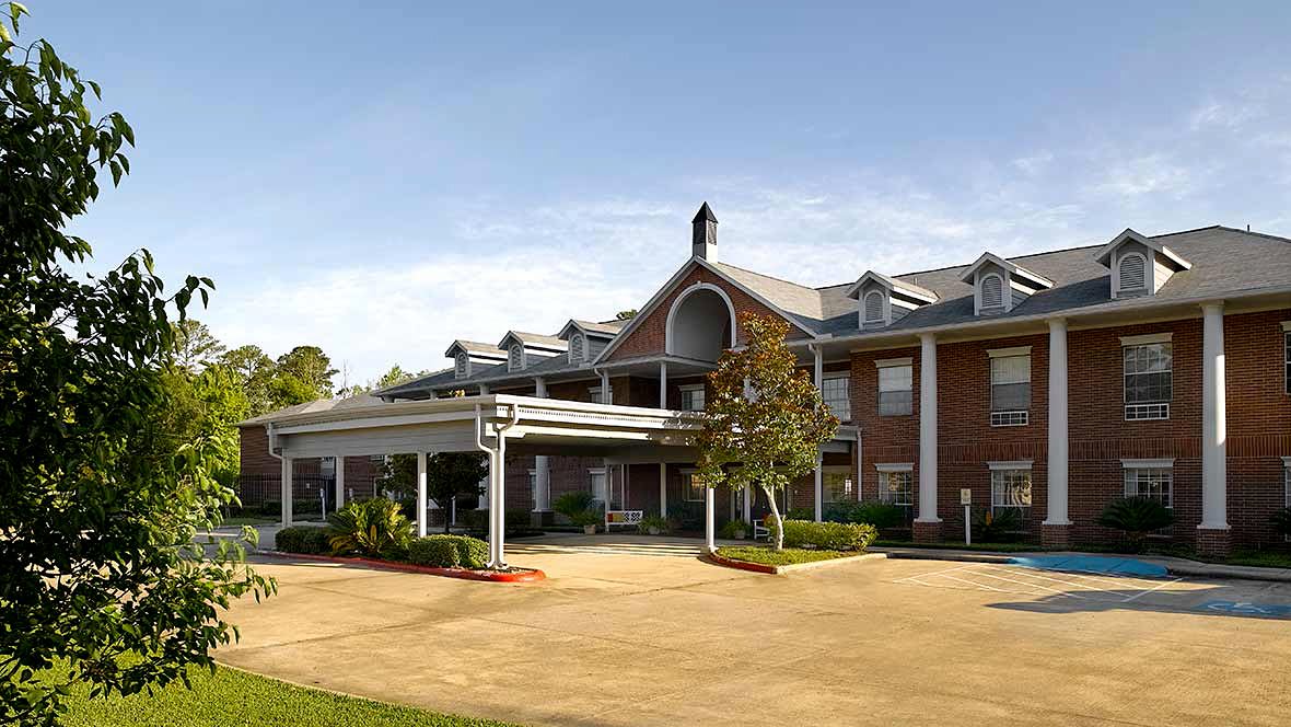 A large, elegant residential building with a landscaped entrance and surrounding greenery.
