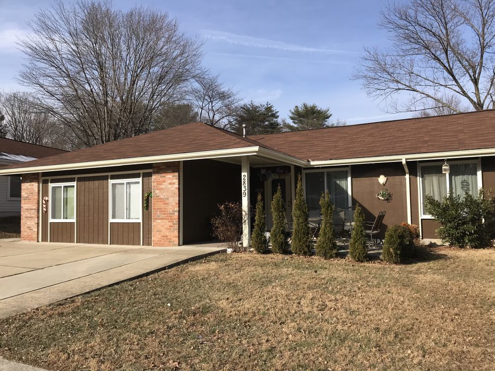 A suburban ranch-style house with a driveway and front lawn.