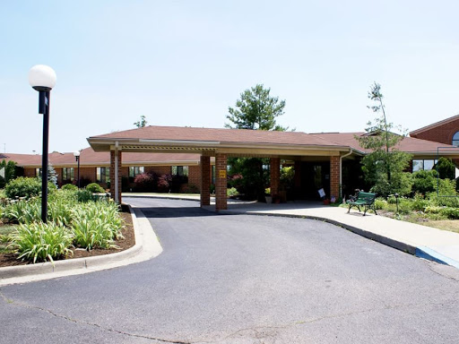 A welcoming entrance to a residential building with a well-maintained driveway and landscaping.