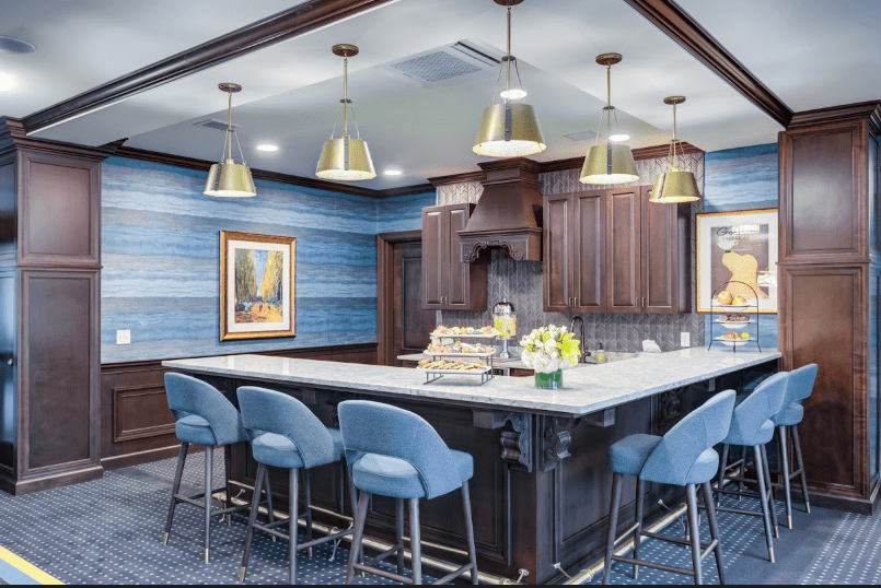 Modern kitchen with a large island and blue upholstered bar stools.