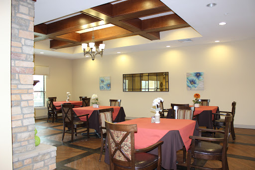 A cozy dining area featuring stylish tables and chairs, complemented by warm lighting and decorative artwork.