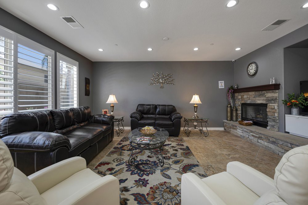 A modern living room with comfortable seating, a patterned carpet, and a cozy fireplace.