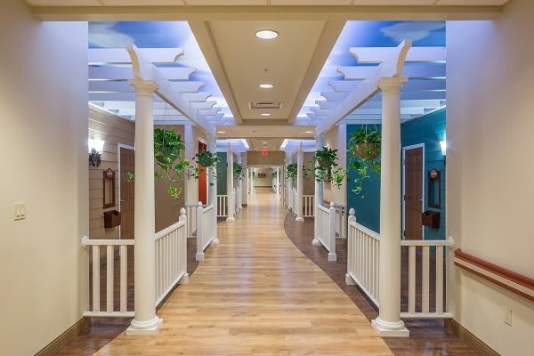 A beautifully designed indoor hallway with decorative columns and an artificial sky ceiling.