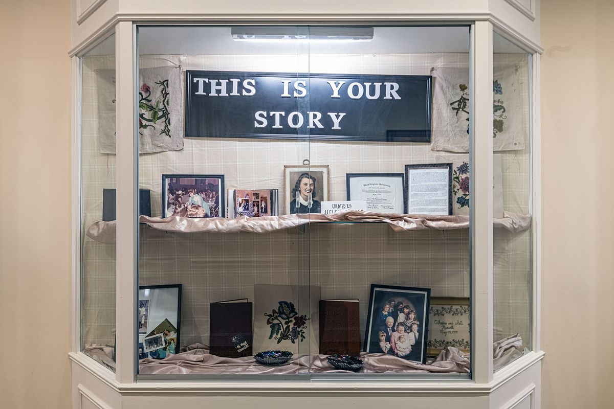 A display case labeled 'This is Your Story' showcasing personal memorabilia and framed photographs.