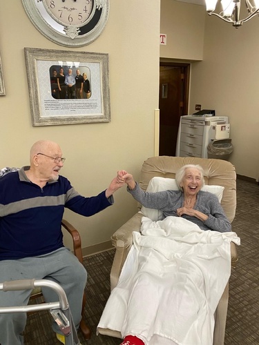 A loving moment shared between an elderly couple in a care facility.