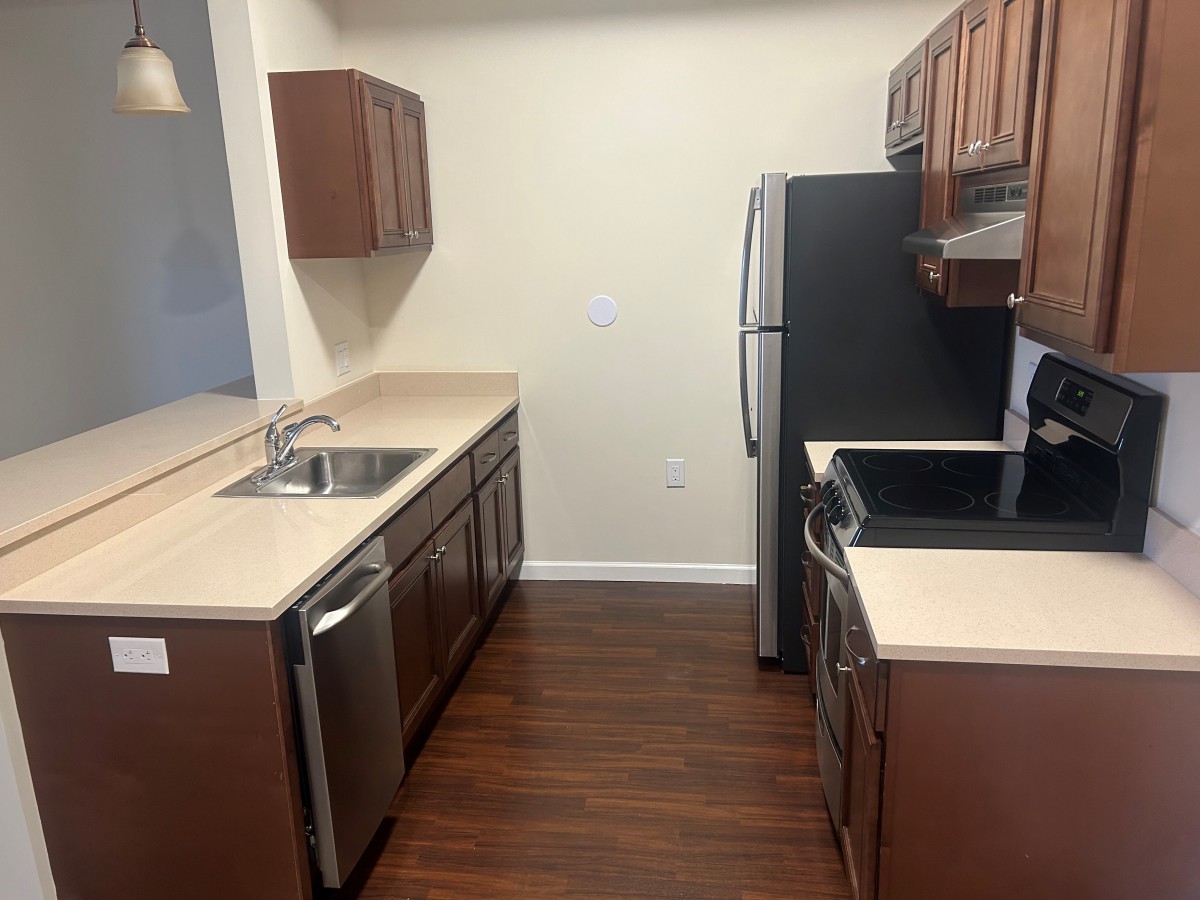 A modern kitchen with wooden cabinets and stainless steel appliances.