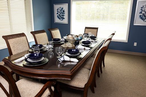 A beautifully set dining table in an elegantly decorated blue dining room, ready for a formal meal.