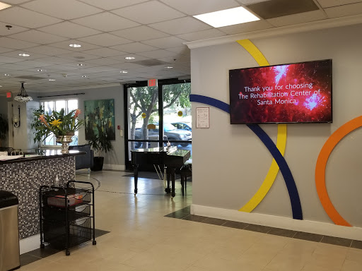 A modern waiting area featuring comfortable seating and a digital display.