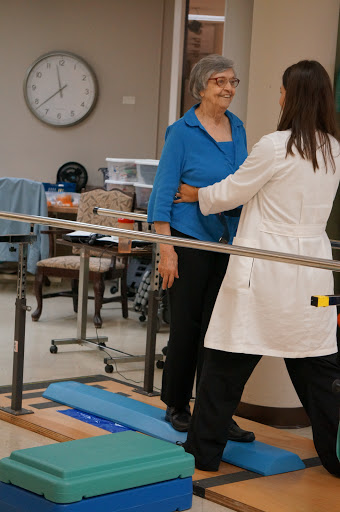 A physical therapist assisting a patient during a rehabilitation session.