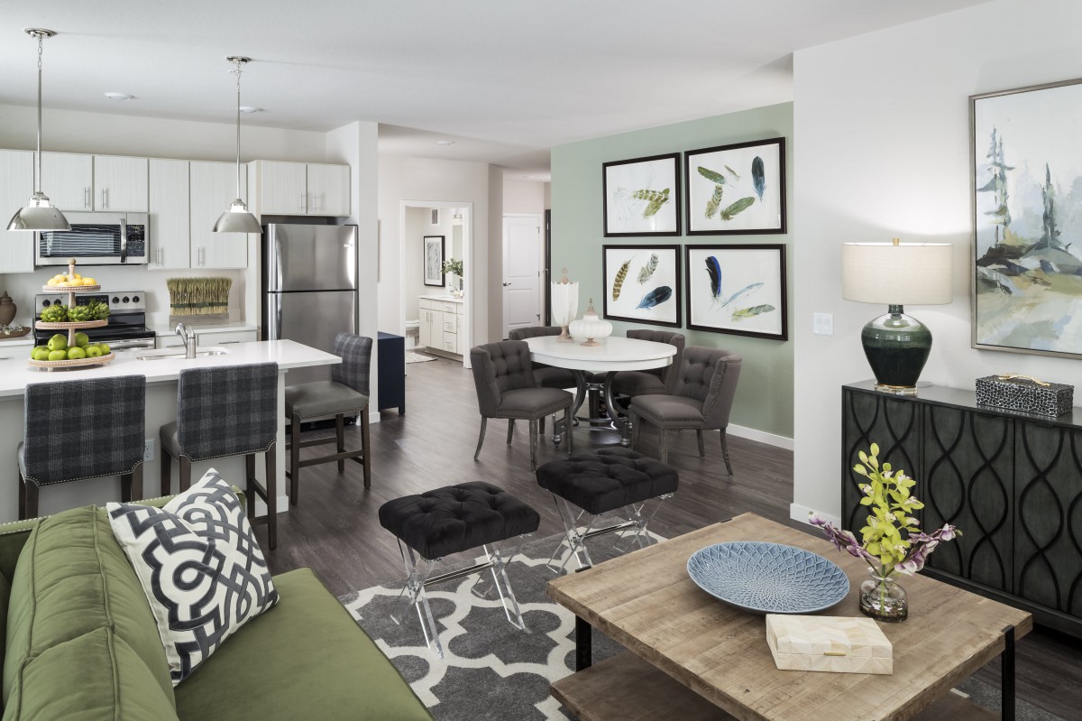 A modern open floor plan featuring a stylish living room, dining area, and kitchen with contemporary decor.