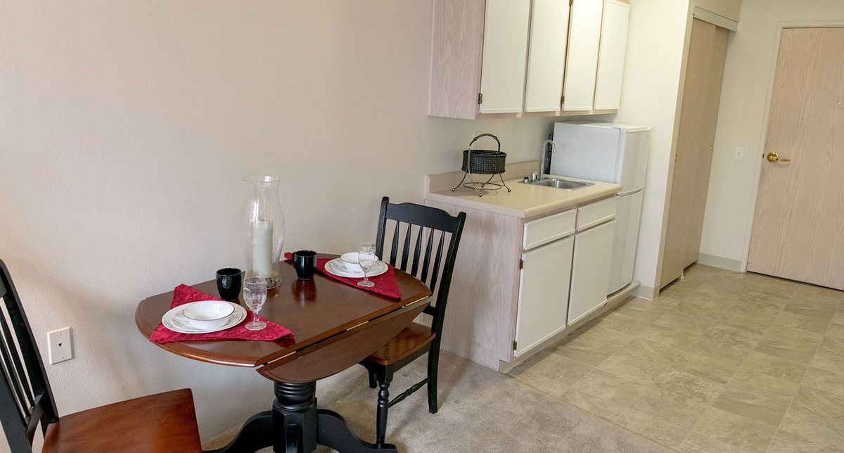 A compact kitchen area with a small dining table set for two.