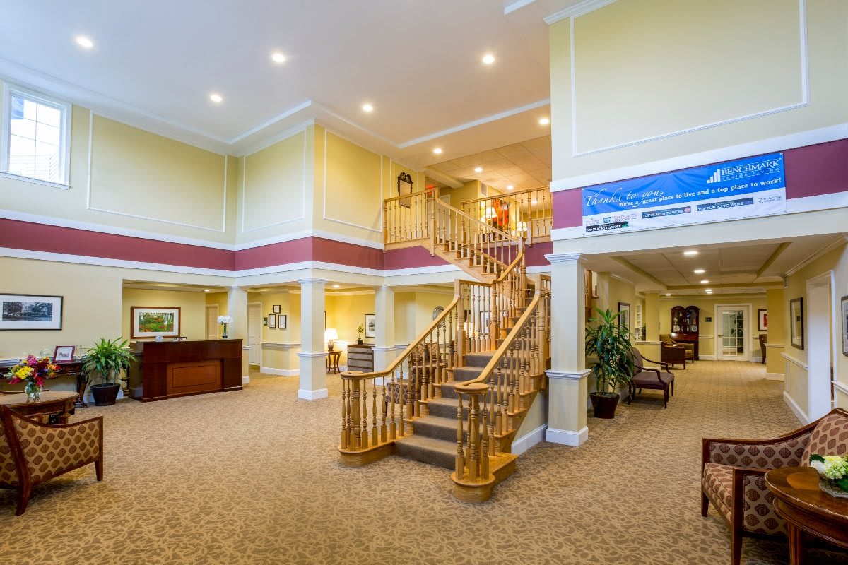 A spacious lobby area with a grand staircase and warm lighting.