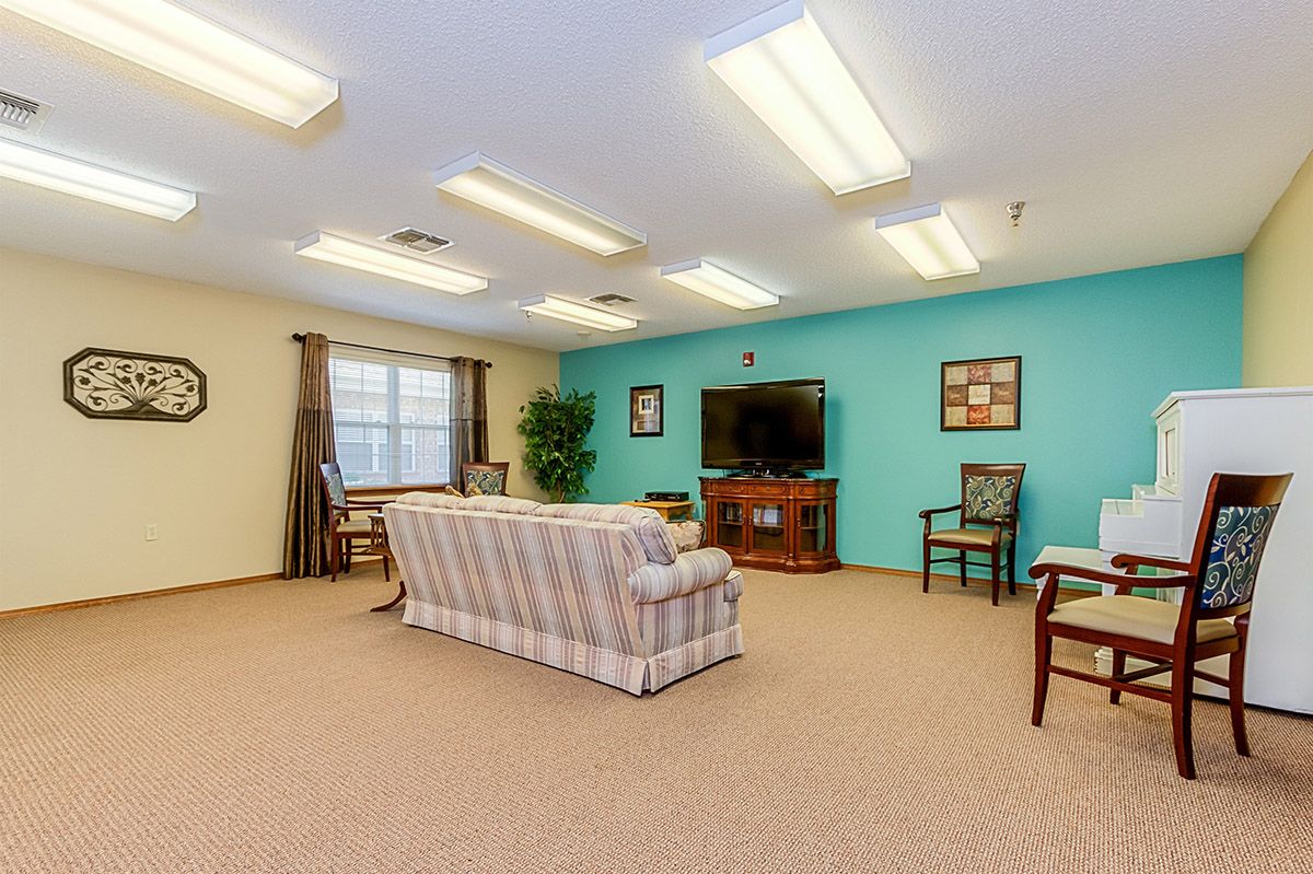 A cozy living room with a sofa, television, and various seating arrangements.