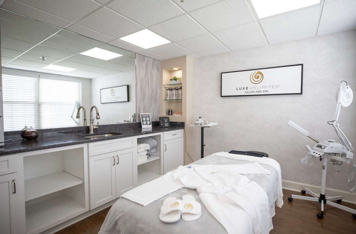 A tranquil spa treatment room featuring a neatly arranged massage table and soothing decor.