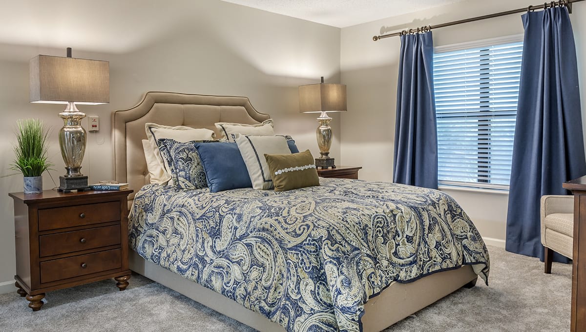 A cozy bedroom with patterned bedding and blue accents.
