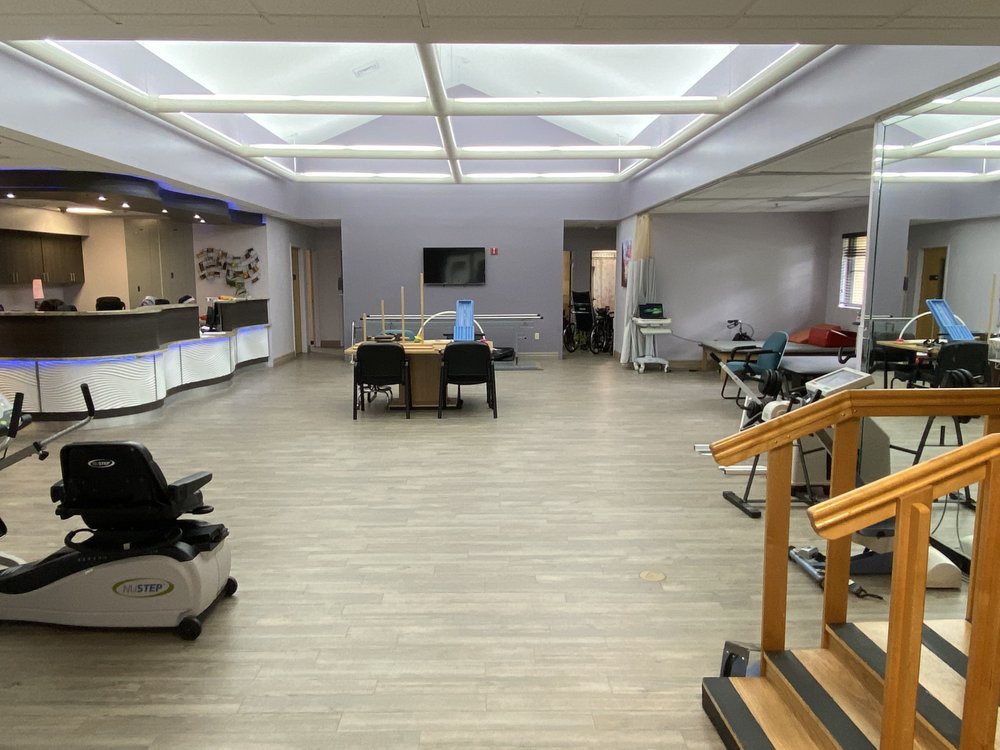 A spacious room with tables, chairs, and rehabilitation equipment.
