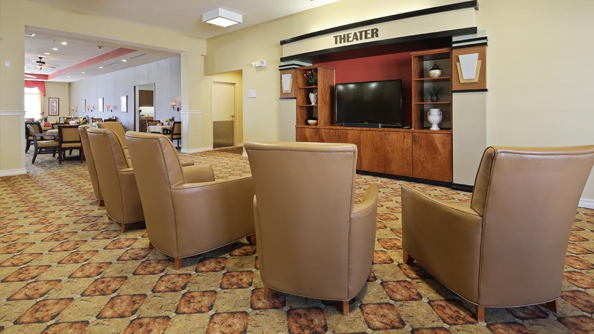 A cozy theater room with comfortable seating arranged around a large television screen, perfect for entertainment.
