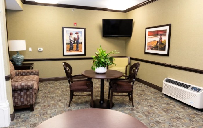 A waiting room with a small table, chairs, and decorative elements.