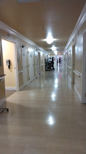 A view down a hospital hallway, lined with patient rooms.