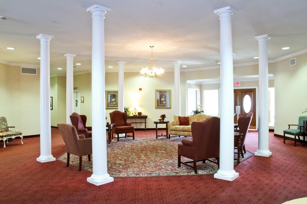 A spacious lobby with elegant columns and comfortable seating.