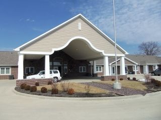 A building entrance with a covered driveway and columns.