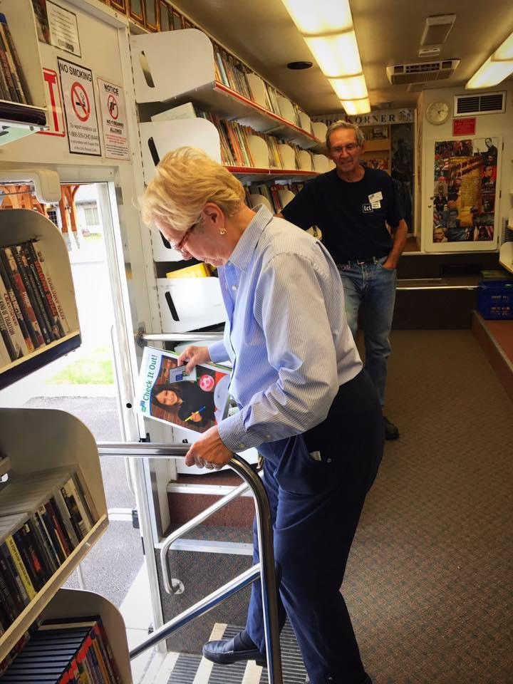 A person browsing through books inside a mobile library.