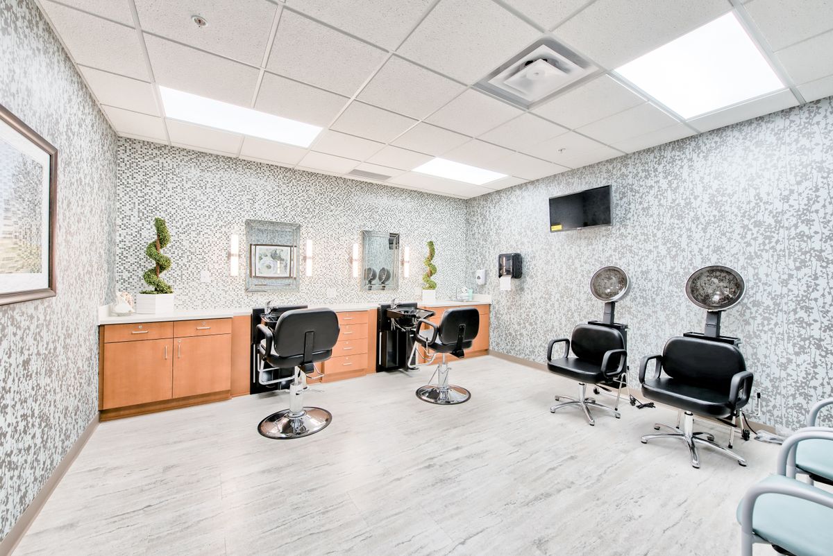 A modern hair salon with stylish decor, featuring multiple chairs and mirrors.