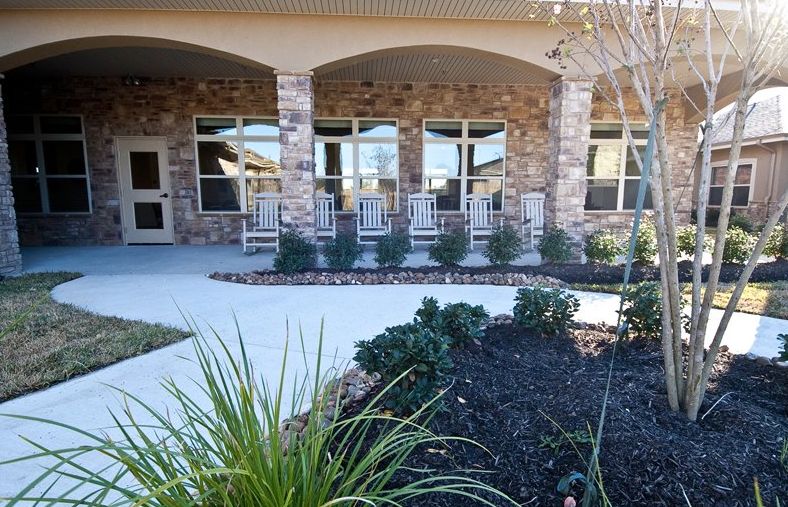 A welcoming porch with rocking chairs outside a stone building.