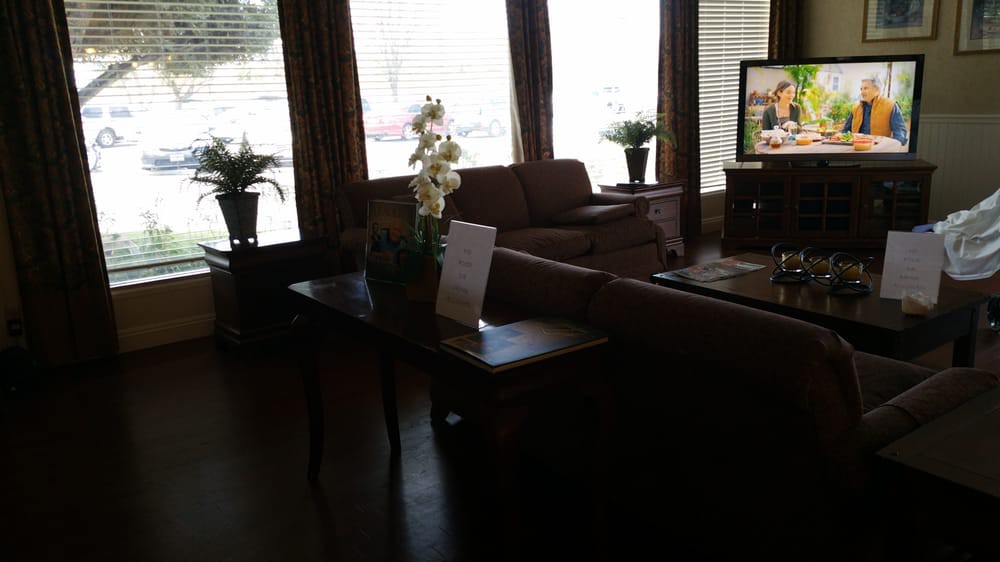 A cozy living room with sofas, a coffee table, and decorative plants.